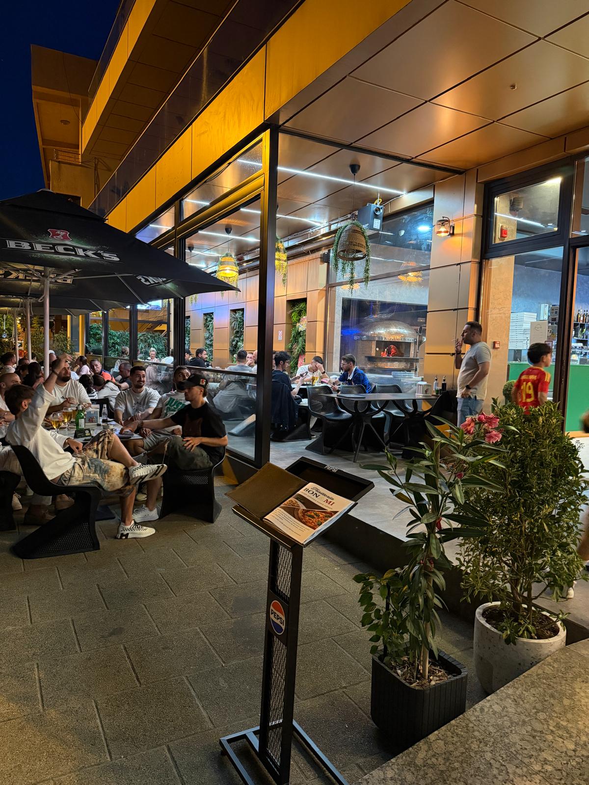 Terasa Trattoria Bona Mi în cursul serii, cu oaspeți la mese